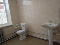 Туалетная комната с дополнительными поручнями. Расположена на первом этаже здания.